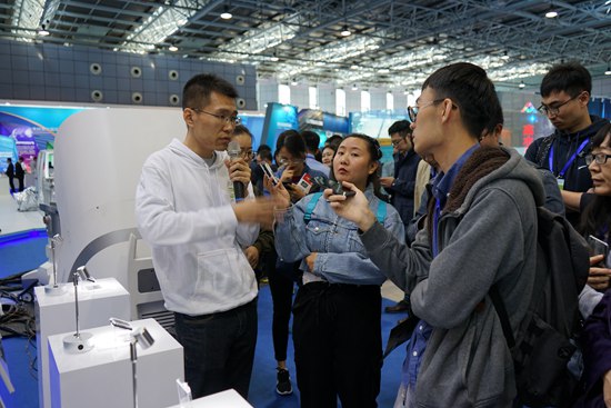 图片4：展位工作人员向媒体讲解.JPG
